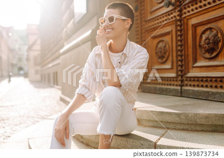 Beautiful woman in stylish clothes and short hair poses. Minimalism, urban style clothes. Beautiful woman in stylish clothes and short hair poses. Minimalism, urban style clothes. 139873734