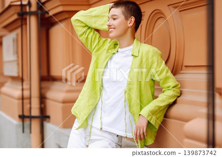 Stylish young woman with short haircut posing on city streets. The concept of fashion, style. 139873742