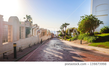 A narrow cobblestone road between houses stretching far into the distance A narrow cobblestone road between houses stretching far into the distance 139873998