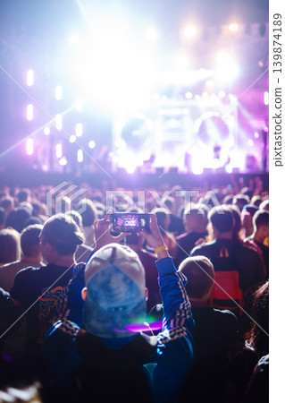 Hand with smartphone records live music festival, Taking photo of concert stage, live concert. 139874189