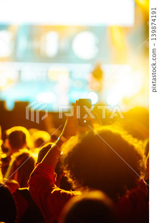 Hand with smartphone records live music festival, Taking photo of concert stage, live concert. Hand with smartphone records live music festival, Taking photo of concert stage, live concert. 139874191