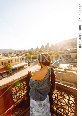 Young woman meditates on terrace with stunning city views in Cappadocia. Concept of active lifestyle 139874752