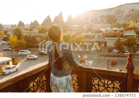 Young woman meditates on terrace with stunning city views in Cappadocia. Concept of active lifestyle Young woman meditates on terrace with stunning city views in Cappadocia. Concept of active lifestyle 139874753