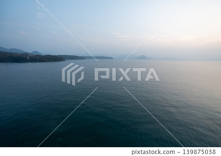 A tranquil seascape in Japan at dusk, with distant islands visible. A tranquil seascape in Japan at dusk, with distant islands visible. 139875038