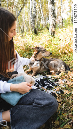 Young woman walking with a dog in an autumn forest 139875399