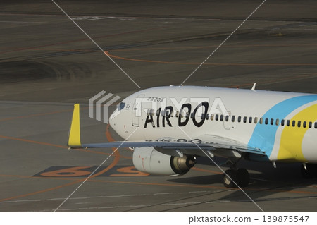A passenger plane heading towards the runway; an Air Do aircraft leaving the parking spot. A passenger plane heading towards the runway; an Air Do aircraft leaving the parking spot. 139875547