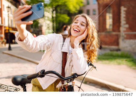 Young woman using mobile phone at the city. Telecommunications, video call conference. Selfie time. Young woman using mobile phone at the city. Telecommunications, video call conference. Selfie time. 139875647