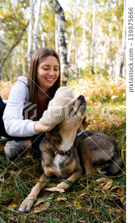 Young woman walking with a dog in an autumn forest Young woman walking with a dog in an autumn forest 139875666