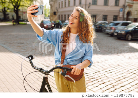 Young woman using mobile phone at the city. Telecommunications, video call conference. Selfie time. Young woman using mobile phone at the city. Telecommunications, video call conference. Selfie time. 139875792