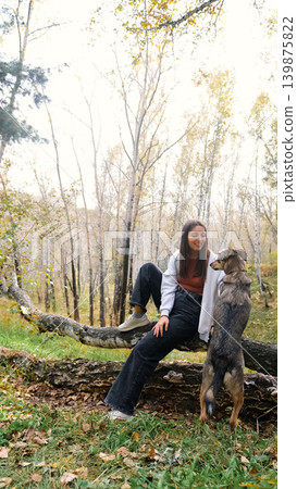 Young woman walking with a dog in an autumn forest Young woman walking with a dog in an autumn forest 139875822