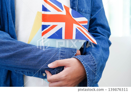 Learn English language, Asian teenage student hold book with flag in course at school. Learn English language, Asian teenage student hold book with flag in course at school. 139876311