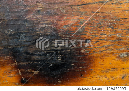 Brown wooden background with the scratch and black burning part Brown wooden background with the scratch and black burning part 139876695