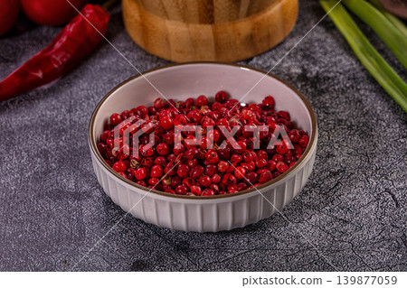 Vibrant Red Pink Peppercorns in Ceramic Bowl on Grey Background Vibrant Red Pink Peppercorns in Ceramic Bowl on Grey Background 139877059