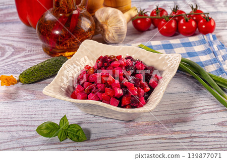 Traditional beetroot salad vinaigrette in white bowl with fresh vegetables on rustic wooden table Traditional beetroot salad vinaigrette in white bowl with fresh vegetables on rustic wooden table 139877071