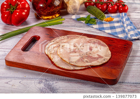Sliced pork and chicken roll appetizer on wooden cutting board with fresh vegetables Sliced pork and chicken roll appetizer on wooden cutting board with fresh vegetables 139877073