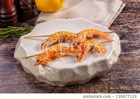 Grilled shrimp skewers on modern white plate with lemon and rosemary Grilled shrimp skewers on modern white plate with lemon and rosemary 139877128
