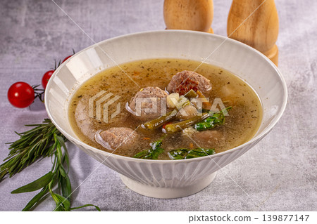 Comforting meatball soup with vegetables and herbs in white bowl 139877147