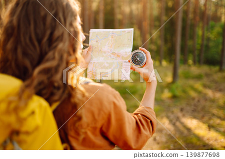 Traveler young woman searching direction with compass on background of map in the forest. Adventure Traveler young woman searching direction with compass on background of map in the forest. Adventure 139877698