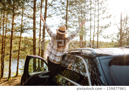 Young woman enjoying and having fun in their vacations outdoors leaning out car window. Summer trip. Young woman enjoying and having fun in their vacations outdoors leaning out car window. Summer trip. 139877961