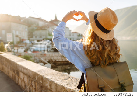 Woman tourist holding hands in shape of heart looking at panoramic landscape of city. Lifestyle. Woman tourist holding hands in shape of heart looking at panoramic landscape of city. Lifestyle. 139878123