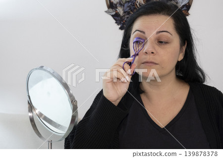 Woman Applying Makeup in Front of Mirror. Woman Applying Makeup in Front of Mirror. 139878378