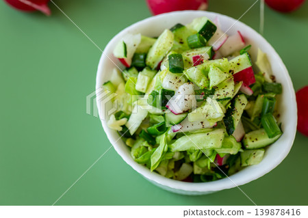 healthy organic salad with fresh spring vegetables on green background healthy organic salad with fresh spring vegetables on green background 139878416