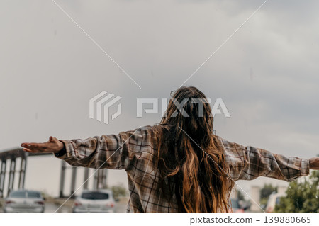 Woman rain freedom woman standing with outstretched arms under a cloudy sky during rain with copy space Woman rain freedom woman standing with outstretched arms under a cloudy sky during rain with copy space 139880665