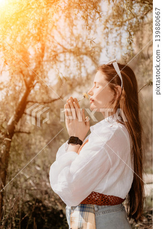 Woman dandelion nature smelling yellow flower with eyes closed during a peaceful mindful moment in a sunlit spring park Woman dandelion nature smelling yellow flower with eyes closed during a peaceful mindful moment in a sunlit spring park 139880667
