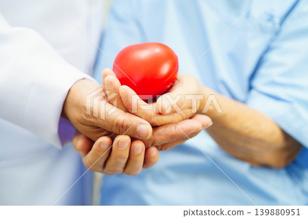 Asian elder senior woman patient holding red heart in hospital. Asian elder senior woman patient holding red heart in hospital. 139880951