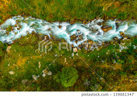 Aerial View of a Mountain Stream Flowing Through Grassy Terrain of Kyrgyzstan Aerial View of a Mountain Stream Flowing Through Grassy Terrain of Kyrgyzstan 139881347