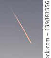 Contrails and the twilight sky, bathed in the setting sun. 139881356