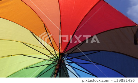 Rainbow umbrella close-up against blue sky Rainbow umbrella close-up against blue sky 139881456