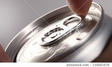 Cola or soda can opening. Close up of hand open aluminum beverage can with pull tab. Refreshing Cola or soda carbonated soft drink container with metal texture condensation droplets and easy open lid 139881670