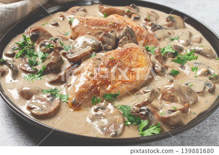 chicken in cream sauce with mushrooms, on a black plate, no people chicken in cream sauce with mushrooms, on a black plate, no people 139881680