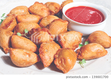 Fried mini chebureks, with sauce, on a decorative plate, hard light, no people, Fried mini chebureks, with sauce, on a decorative plate, hard light, no people, 139881700