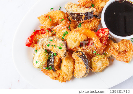 Shrimp and vegetable tempura, served with dipping sauce, on a white plate Shrimp and vegetable tempura, served with dipping sauce, on a white plate 139881713