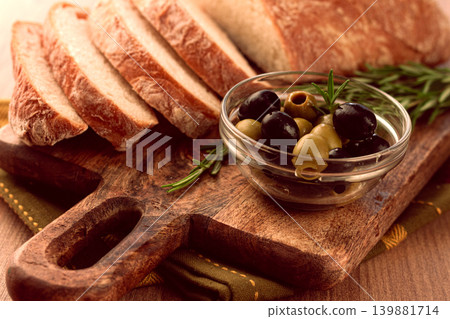 sliced ciabatta , on a chopping board, with rosemary and olives, Italian bread, close-up, Italian cuisine, breakfast, no people, sliced ciabatta , on a chopping board, with rosemary and olives, Italian bread, close-up, Italian cuisine, breakfast, no people, 139881714