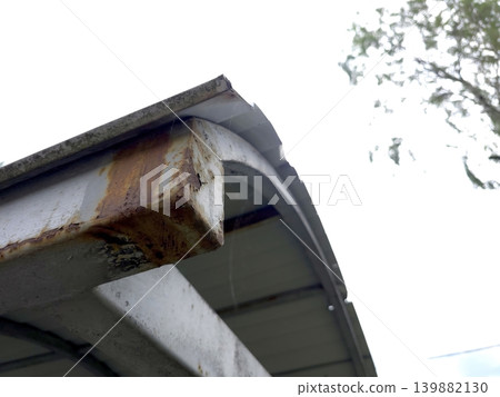 Metal Canopy Construction Showing Rust and Wear Near a Tree 139882130