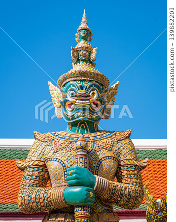 A green-faced yaksha guardian Thotsakan against blue sky at Wat Phra Kaew, Grand Palace, Bangkok, Thailand A green-faced yaksha guardian Thotsakan against blue sky at Wat Phra Kaew, Grand Palace, Bangkok, Thailand 139882201