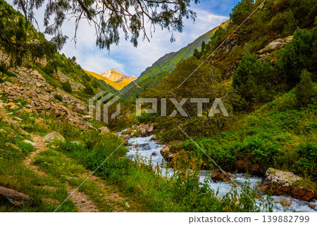Scenic Mountain Valley with Stream and Hiking Path in Kyrgyzstan Scenic Mountain Valley with Stream and Hiking Path in Kyrgyzstan 139882799