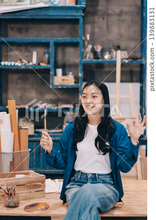 Female artist wears black hat posing near picture indoor the studio Female artist wears black hat posing near picture indoor the studio 139883131