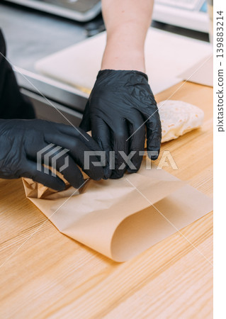 Serving fast food. Doner kebab seller. Gloved chef hand packing tasty tortilla pita bread in paper. Takeaway burrito lunch business. Serving fast food. Doner kebab seller. Gloved chef hand packing tasty tortilla pita bread in paper. Takeaway burrito lunch business. 139883214