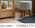 Cozy knitted stool near wooden shelf warm home interior decor 139883774