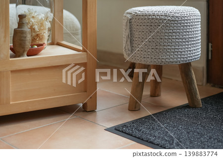 Cozy knitted stool near wooden shelf warm home interior decor 139883774