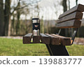 Thermos cup on wooden bench in park calm morning scene 139883777