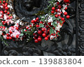 The red berries on a Christmas wreath on a metal door 139883804