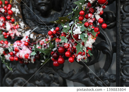 The red berries on a Christmas wreath on a metal door The red berries on a Christmas wreath on a metal door 139883804