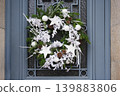Christmas wreath with branches and white balls on a glass door 139883806