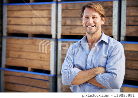 Happy, portrait and mature man by wooden crates for delivery, shipping or exporting business. Industry, storage and professional male person crossed arms by pallets at outdoor distribution warehouse. Happy, portrait and mature man by wooden crates for delivery, shipping or exporting business. Industry, storage and professional male person crossed arms by pallets at outdoor distribution warehouse. 139883991