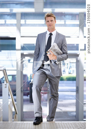 Business man, newspaper and travel at airport for portrait with walking, suitcase and commute on trip. Professional person, luggage and corporate employee with pride on steps with suit in lobby 139884028
